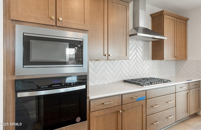 kitchen featuring tasteful backsplash, wall chimney range hood, and appliances with stainless steel finishes