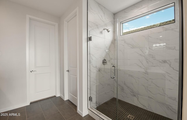 bathroom with a shower with door and tile patterned floors