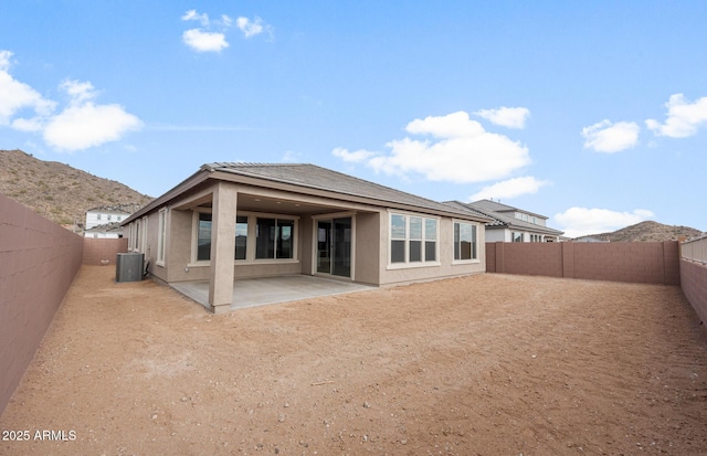 rear view of house with a mountain view, cooling unit, and a patio area