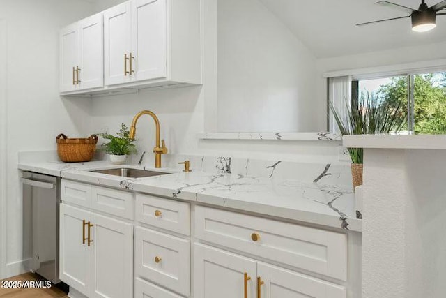 kitchen with stainless steel dishwasher, white cabinets, sink, and vaulted ceiling