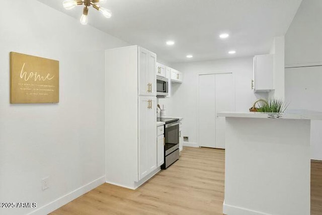 kitchen with kitchen peninsula, light hardwood / wood-style floors, white cabinetry, and stainless steel appliances