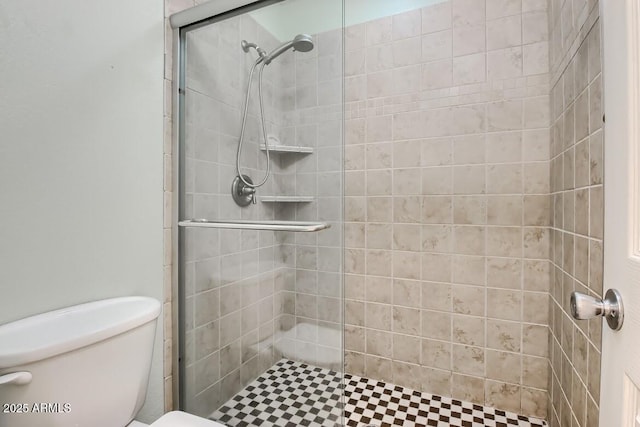 bathroom featuring toilet and a stall shower