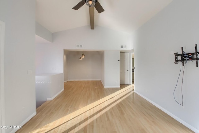 empty room featuring lofted ceiling with beams, wood finished floors, visible vents, and baseboards