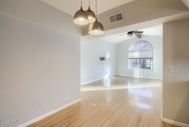 empty room featuring baseboards, wood finished floors, visible vents, and a ceiling fan