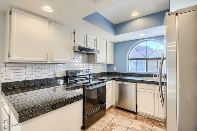 kitchen with tile counters, decorative backsplash, appliances with stainless steel finishes, under cabinet range hood, and white cabinetry