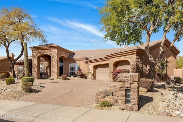 mediterranean / spanish-style home with a garage, stone siding, driveway, and stucco siding