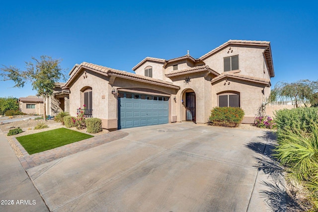 mediterranean / spanish-style house with concrete driveway, a tiled roof, an attached garage, and stucco siding