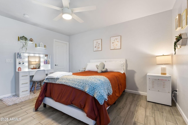 bedroom with wood finish floors, a ceiling fan, and baseboards