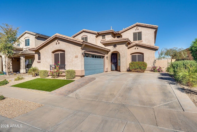 mediterranean / spanish house featuring a garage, driveway, a tiled roof, and stucco siding