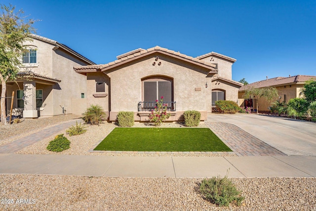 mediterranean / spanish home featuring decorative driveway, a tile roof, and stucco siding