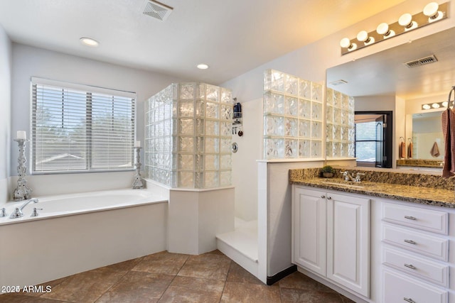 full bathroom featuring visible vents, vanity, a bath, and walk in shower