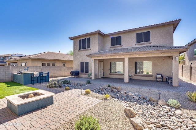 back of property featuring a patio area, a fenced backyard, a fire pit, and stucco siding