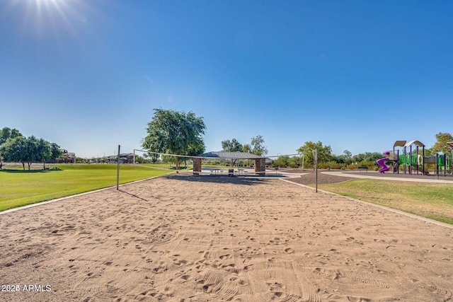 surrounding community with playground community, a lawn, and volleyball court