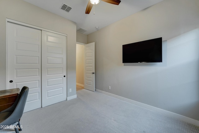 carpeted home office featuring ceiling fan