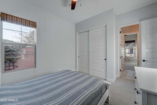 carpeted bedroom with ceiling fan and a closet