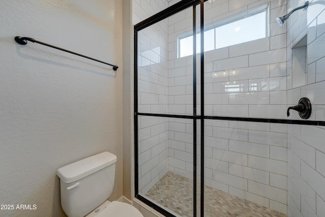 bathroom featuring walk in shower and toilet