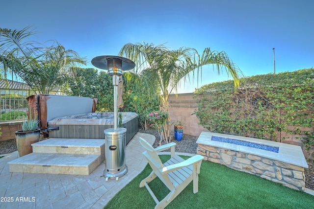 view of patio / terrace featuring a hot tub and a fire pit