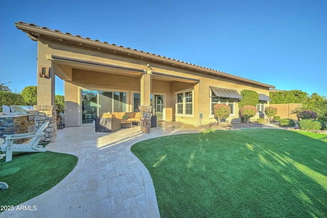 back of house featuring exterior kitchen, a yard, and a patio area