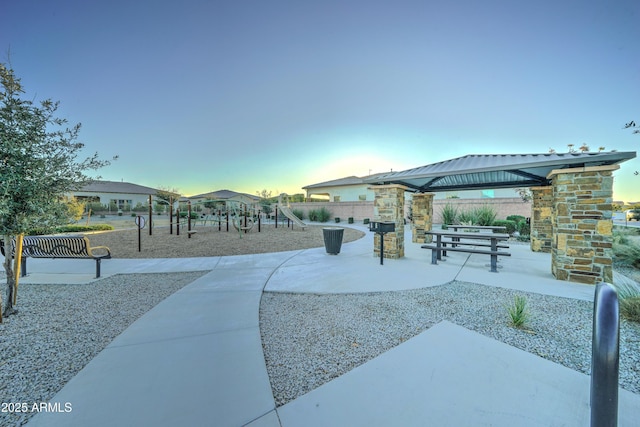 view of home's community featuring a playground and a patio area