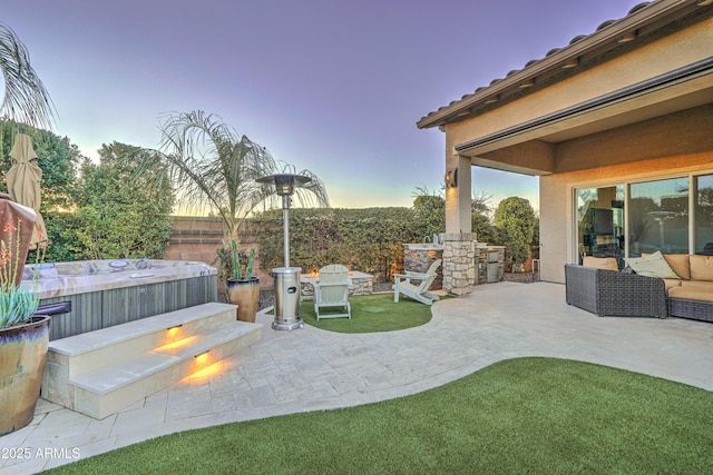 patio terrace at dusk with a hot tub and outdoor lounge area