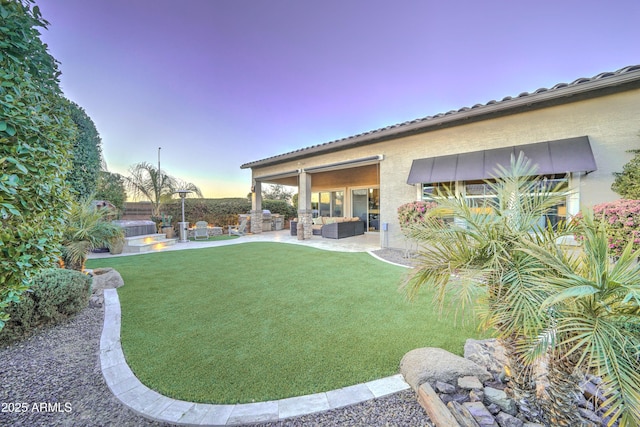 yard at dusk with outdoor lounge area and a patio