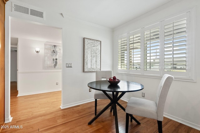 dining space featuring crown molding and hardwood / wood-style flooring