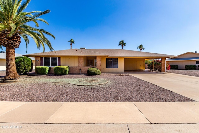 ranch-style house featuring a carport, brick siding, and driveway