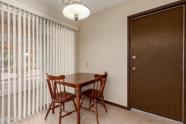 dining area featuring light tile patterned floors and baseboards