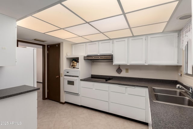 kitchen with black electric stovetop, dark countertops, a sink, oven, and under cabinet range hood