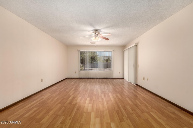 empty room featuring a textured ceiling, ceiling fan, light wood finished floors, and baseboards