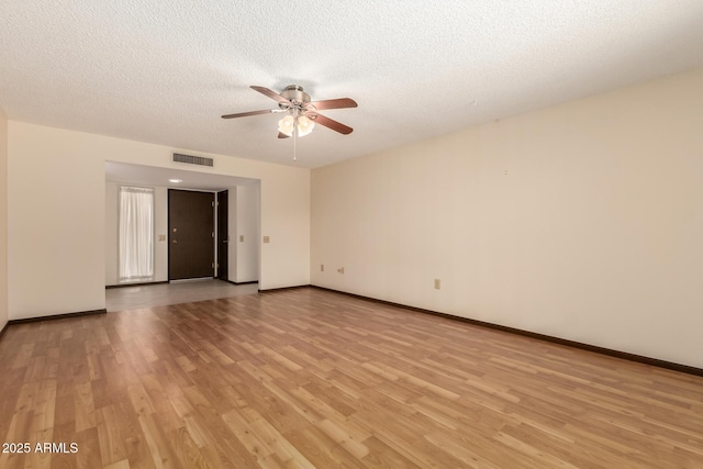 empty room with light wood-type flooring, ceiling fan, visible vents, and a textured ceiling