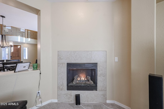 details featuring a tile fireplace and carpet