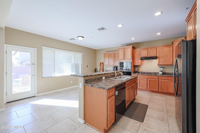 kitchen featuring sink, dark stone countertops, a kitchen island with sink, light tile patterned floors, and black appliances