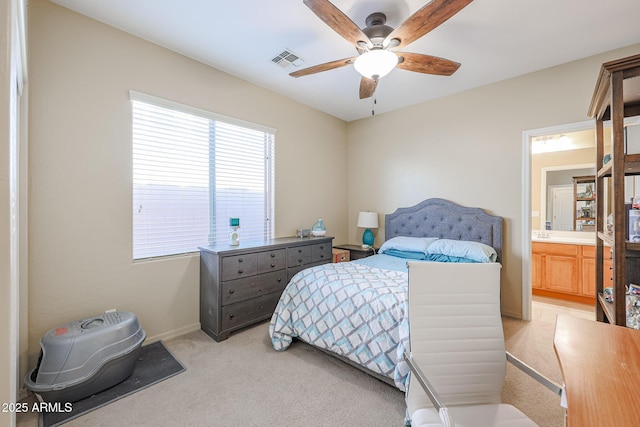 bedroom featuring ceiling fan, ensuite bathroom, and light carpet