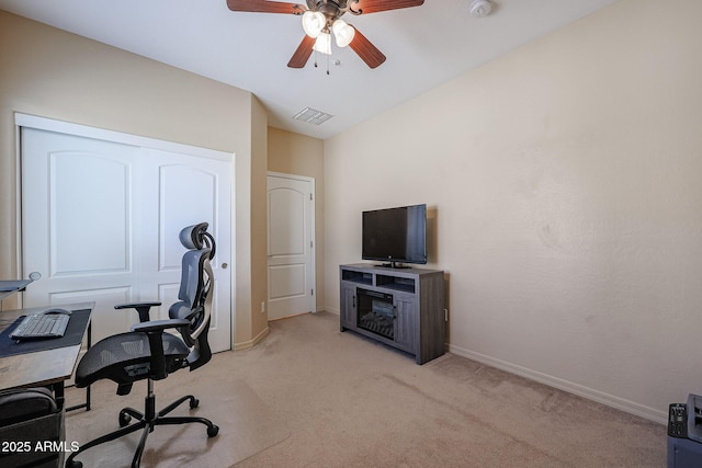 carpeted office space featuring ceiling fan