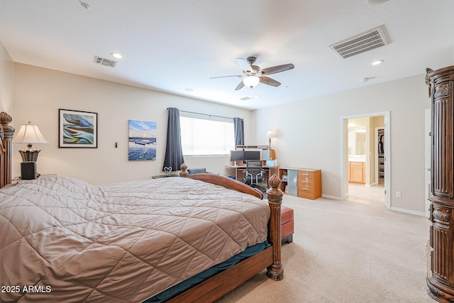 bedroom featuring ceiling fan, light colored carpet, and ensuite bathroom