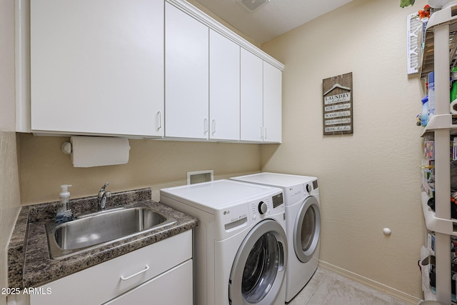 clothes washing area with washer and dryer, light tile patterned flooring, cabinets, and sink