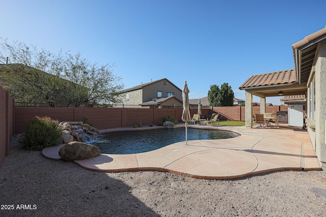 view of swimming pool featuring pool water feature, ceiling fan, and a patio area