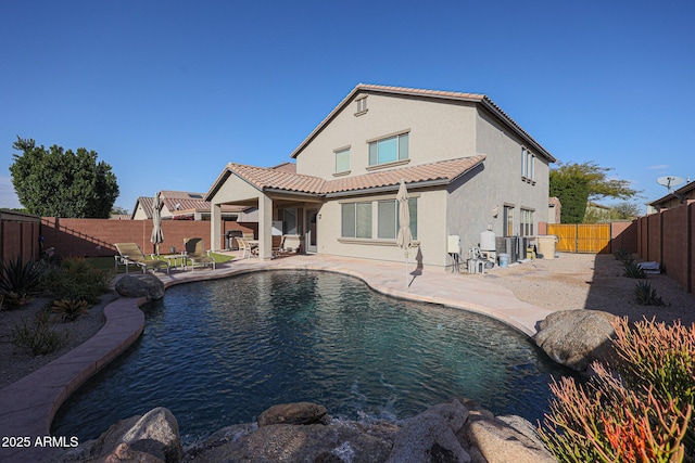 back of property featuring a fenced in pool and a patio area