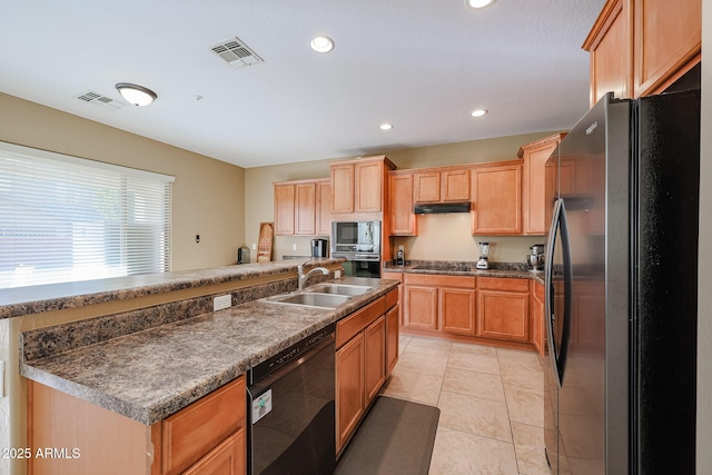 kitchen featuring black appliances, light tile patterned flooring, sink, and an island with sink