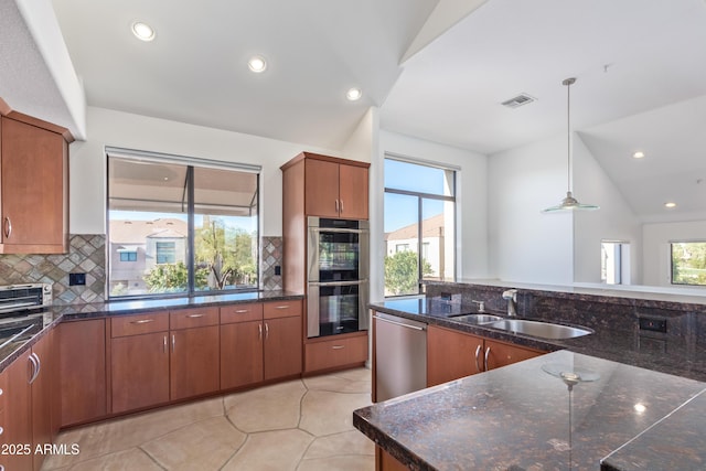 kitchen featuring appliances with stainless steel finishes, pendant lighting, a wealth of natural light, and lofted ceiling