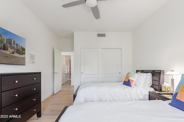 bedroom featuring ceiling fan, light hardwood / wood-style flooring, and a closet