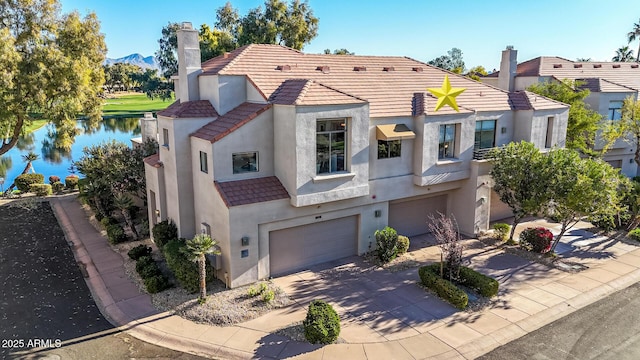 mediterranean / spanish home featuring a garage and a water view