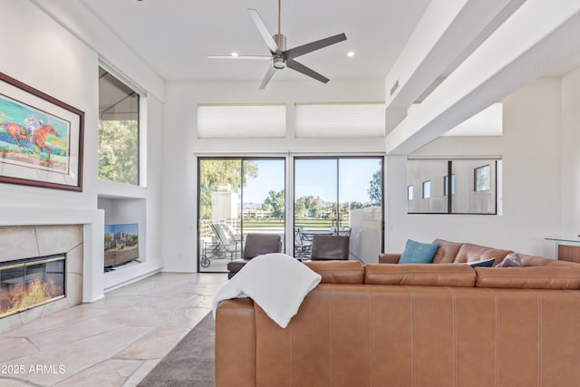 living room featuring a high end fireplace and ceiling fan