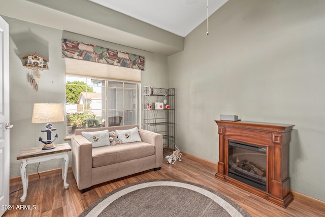 sitting room with wood-type flooring and vaulted ceiling