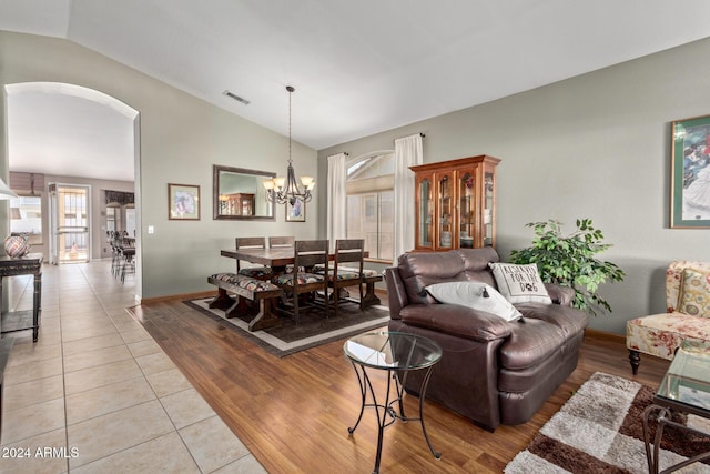 tiled living room with a chandelier and lofted ceiling