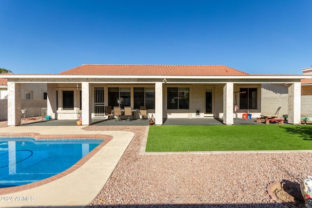 back of property with a yard and a patio