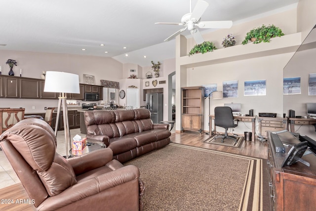 living room with light wood-type flooring, high vaulted ceiling, and ceiling fan