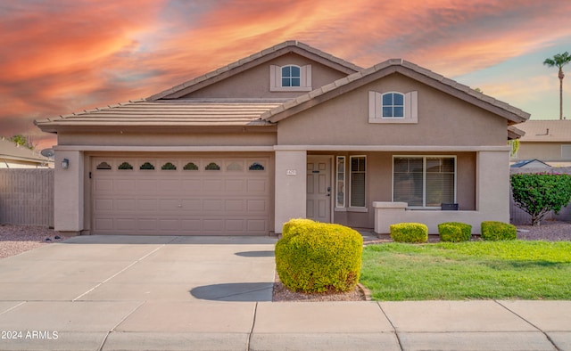 view of front property featuring a garage and a yard