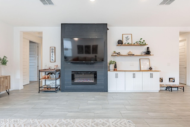 living area with visible vents and a large fireplace